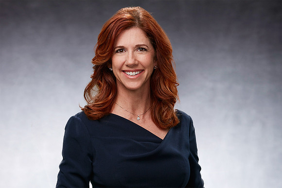 Professional Business Portrait of female executive on a grey background. She is smiling and  looking very professional
