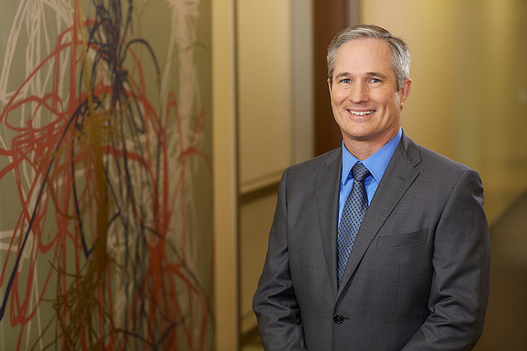 Business Headshot in Sacramento of a male executive looking relaxed and smiling at the camera.