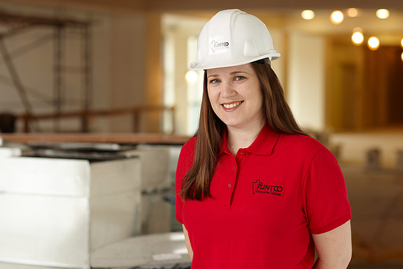 Professional on-site business portrait of girl with hard-hat facing camera.