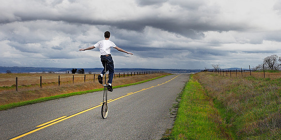 Commercial photography of a unicyclist on a country road