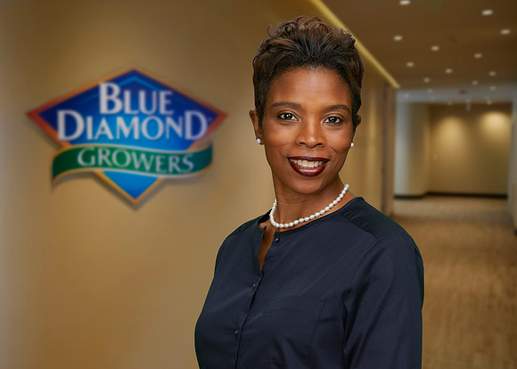 Simone Denny in hallway w Blue Diamond Logo Background-7x5-print-