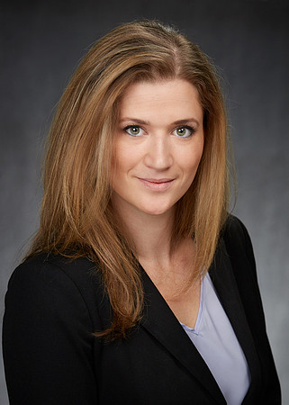 Professional Business Portrait of a woman in a jacket and blouse smiling at the camera.